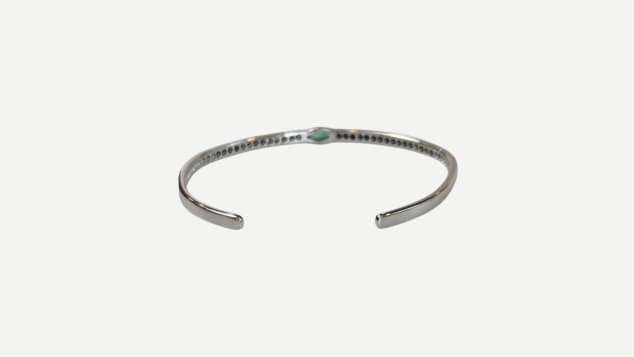 Foto 4: Bracelete em ouro branco 18k, com aproximadamente 1.00 cts de diamantes redondos e 0.50 cts de esmeralda lapidação navete. Peso total: 10,6 gramas. Medida: 5 cm de diâmetro.